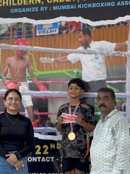 A young champion with his proud parents at the kickboxing championship. We believe in involving the family in a child's martial arts journey.