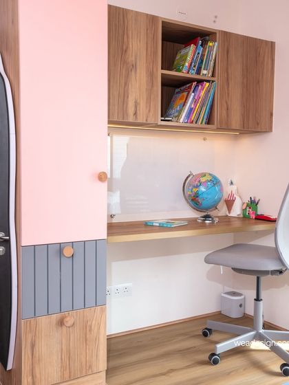 The study area in the Sobha Royal Pavilion kids' room, with a wooden laminate desk, overhead storage, and a white marker board for creative expression.