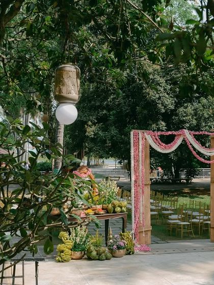 A wide shot of the outdoor venue, showing the floral archway in the distance and other decor elements that create a welcoming atmosphere.