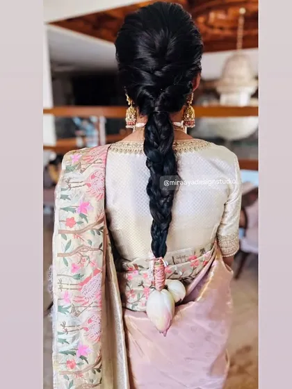 A back view showing the elegant hairstyle and the custom-designed blouse, which features subtle embroidery along the neckline.