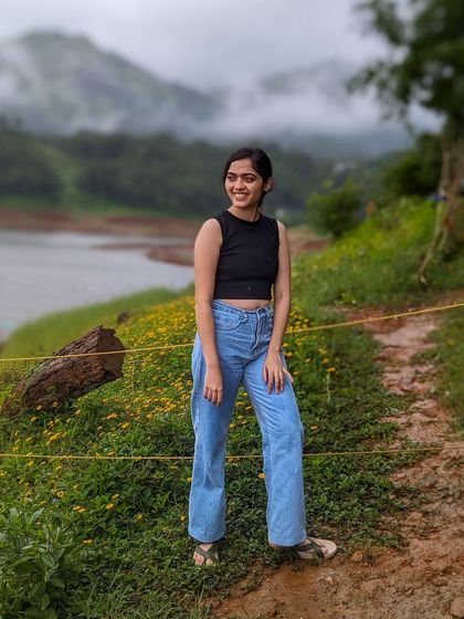 A trekker posing by the Banasura Sagar Dam in Wayanad.