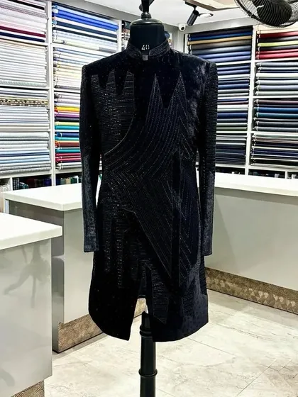 A modern, longline Indo-Western sherwani in black. The geometric, textured pattern gives it a contemporary edge, perfect for a client who wants a fusion look.