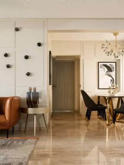 A wider view of the living and dining space, illustrating how I balanced the client's existing brown marble floor with a monochrome palette, pops of color, and statement rugs to create a fresh, modern aesthetic.