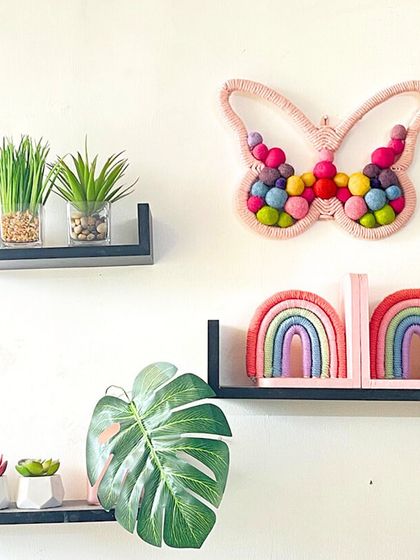 This butterfly wall art, filled with colorful felt balls, is paired with my rainbow bookends on a shelf. It shows how you can mix and match different handmade pieces to create a cohesive and cheerful decor theme.