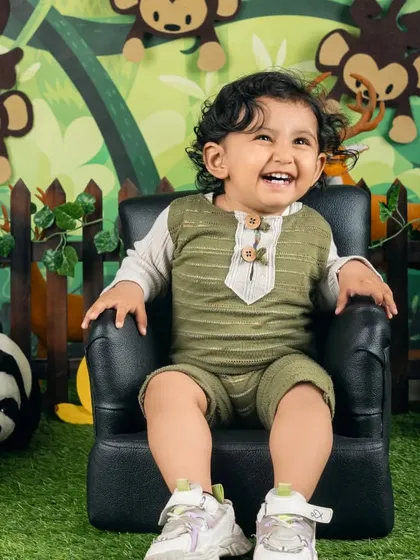 A big, joyful laugh from this little explorer during her jungle-themed photoshoot. Her happiness is contagious!