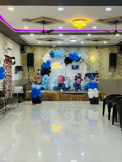 A wide view of the Boss Baby themed party hall decoration. I ensure the entire space, from the entrance to the main stage, reflects the chosen theme with balloon columns and personalized photo displays for guests to enjoy.