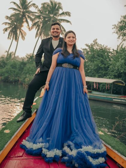 A romantic pre-wedding shoot on a boat. The royal blue ruffled gown is a showstopper, perfect for creating a memorable look.