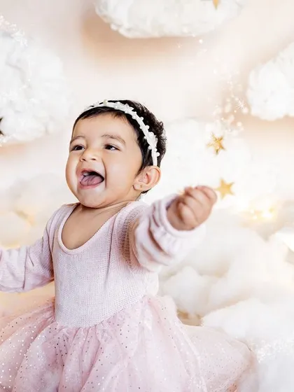 Let's bring your creative ideas to life! For little Taarika's first birthday, we created this dreamy "above the clouds" setup right in her home. It was a star-studded shoot for a little star, showing how we can design a unique and personal session for you.
