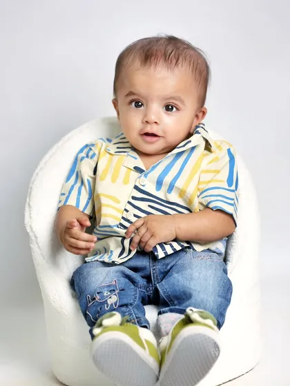 An individual portrait of the other twin, looking sharp in his casual outfit. These solo shots perfectly complement the photos of them together.