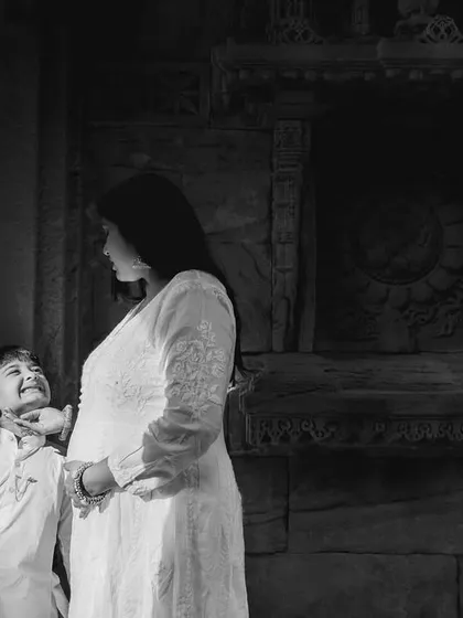 A playful moment between mother and son captured in black and white. The textured stone walls provide a beautiful contrast to their bright outfits.