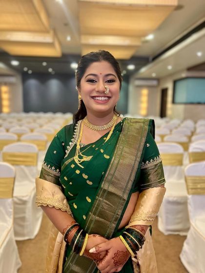 A happy Maharashtrian bride ready for her big day. The look is traditional yet soft, with a glowy base and kohl-defined eyes.