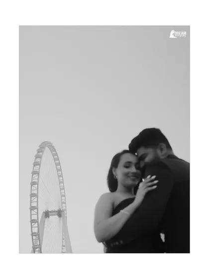 A tender black and white close-up with the Ain Dubai wheel in the background, blending an iconic landmark with a personal, intimate moment.