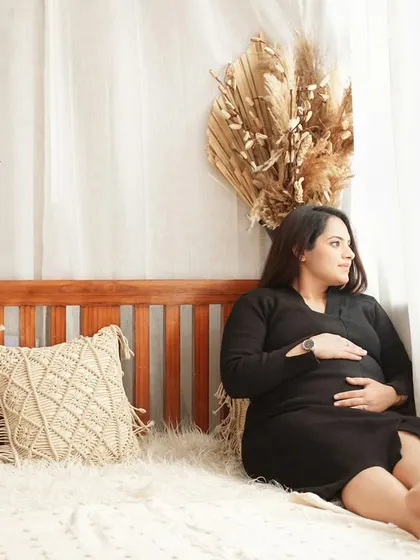The mom-to-be relaxes on the bed, looking out the "window" created by our bright studio lights. A beautiful, contemplative portrait.