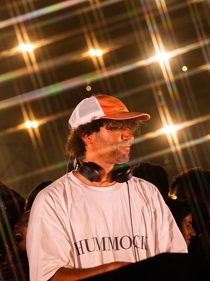 A cool, artistic shot of &ME with a lens flare effect, capturing the unique, stylish vibe of his performance.