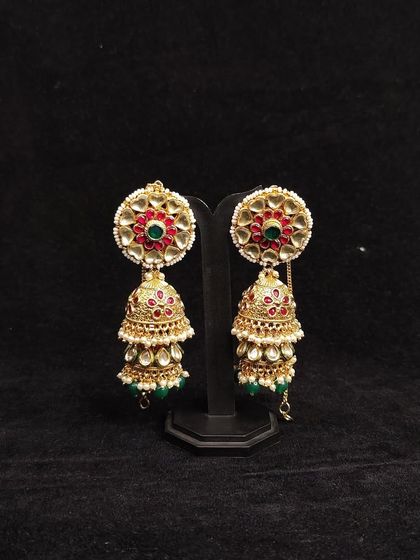 A pair of classic jhumkas with red and green enamel work. Rent these to pair with a traditional saree or lehenga.