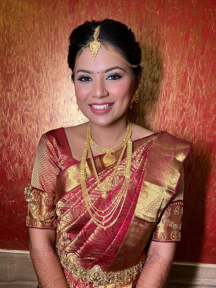 A smiling portrait that captures the essence of a happy, glowing South Indian bride in her element.