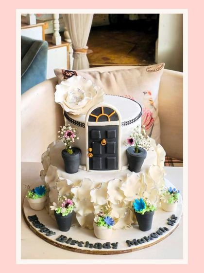 A unique cake designed to look like a Parisian storefront, with a charming door and potted plants.