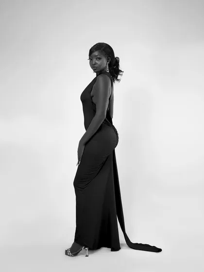 A full-length side profile. The long train of the dress adds a beautiful line to the composition.