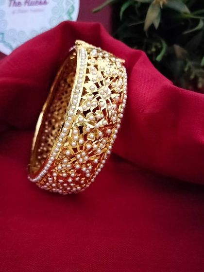 The 'रातरानी' (Rat-rani) openable bangles. These feature a delicate filigree design with tiny pearls, offering a very sophisticated and elegant look.