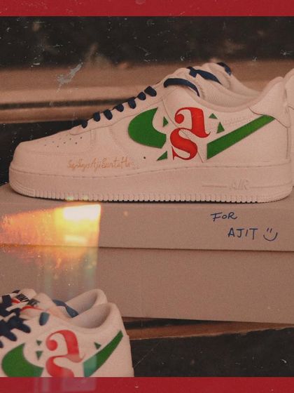 The two pairs of custom sneakers for the couple, side-by-side. One pair of Air Force 1s and one pair of Blazers, both featuring the same custom initial design.