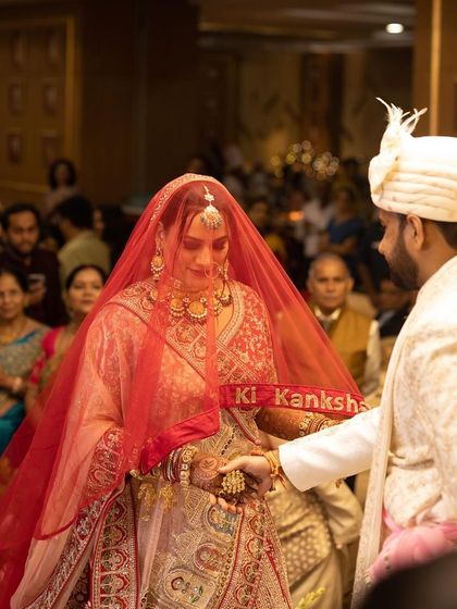 A candid shot from the wedding ceremony. Even under the veil, the bride's makeup is visible and radiant, highlighting her features beautifully.