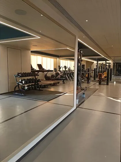 The fully equipped residential gym at The Bandra Project, featuring mirrored walls and modern fitness equipment for residents.
