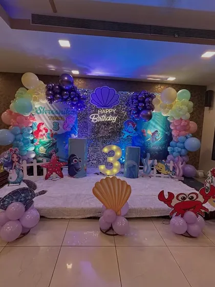 Dive into an underwater adventure! This enchanting Mermaid theme was for a 3rd birthday in Chembur. I used a shimmering sequin backdrop, character cutouts of Ariel and her friends, a light-up number '3', and balloon sculptures of crabs and octopuses to bring the ocean magic to life.