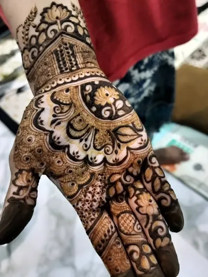 A beautiful design on the back of the hand, featuring a mix of floral and paisley motifs. The use of negative space makes the flowers stand out.