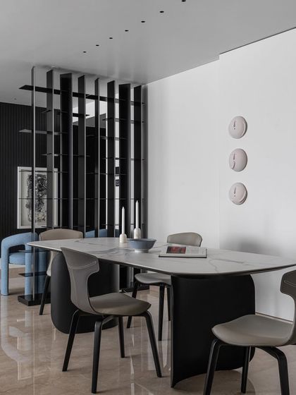 A modern dining space that is "TOO GORG". The sleek marble-topped table is paired with contemporary chairs and a striking black slatted room divider, creating a look that is both bold and sophisticated.