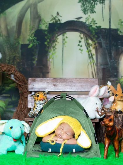 Camping in the jungle with all his animal friends. This newborn is sleeping peacefully in a tiny tent.