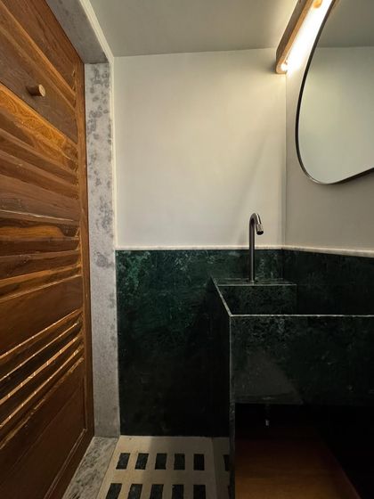 The bathroom in our studio extension, showcasing a custom-designed sink and wainscoting made from Baroda Green Marble. This demonstrates how indigenous materials can be used to create refined and modern designs.