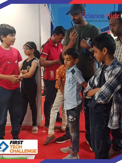 A young visitor listens intently as our students explain their project at the FTC India Championship. Our teams learn to communicate complex ideas clearly and inspire curiosity in others.