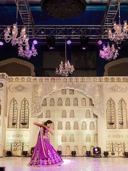 The bride's solo performance on a stage designed to feel like a part of a Rajasthani palace. The thikri work and architectural arches provided a stunning, non-distracting backdrop that enhanced her graceful dance.
