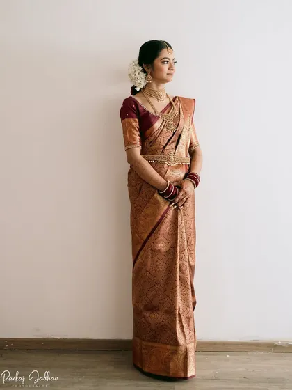 A full-length portrait of bride Aditi in her magnificent Kanjivaram saree, a picture of South Indian bridal elegance.