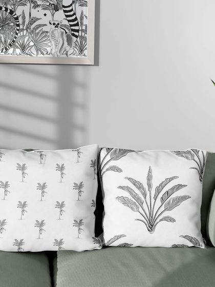 My Madagascar-themed patterns on a set of throw pillows. Mixing and matching different monochrome prints from the same collection, like the lemur-on-palm and the tropical plant, creates a cohesive and stylish look.