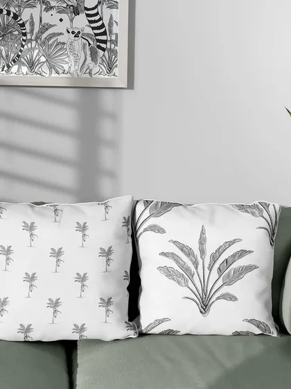 My Madagascar-themed patterns on a set of throw pillows. Mixing and matching different monochrome prints from the same collection, like the lemur-on-palm and the tropical plant, creates a cohesive and stylish look.