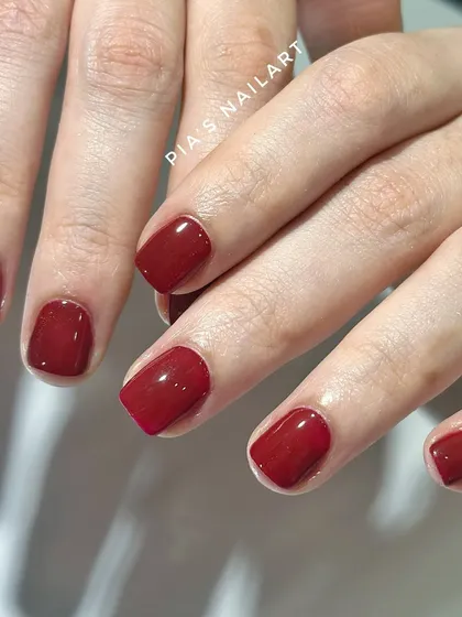 A beautiful, classic red gel polish on short, natural nails. It's a timeless look that never goes out of style.
