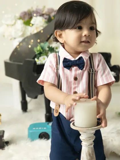 A thoughtful moment with a candle prop. The warm, soft lighting adds a touch of elegance to this dapper little boy's photoshoot.