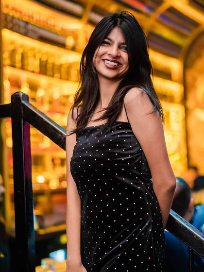 A guest in a black polka-dot dress, smiling for the camera.