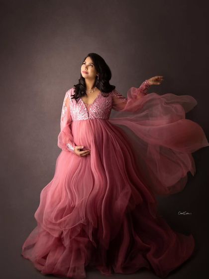 The movement in this shot is everything. The mom-to-be looks ethereal as the flowing fabric of her pink gown seems to float around her.