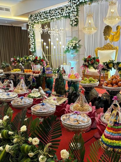 A detailed view of an offering table with peacock props, elephant stands, and traditional dolls.