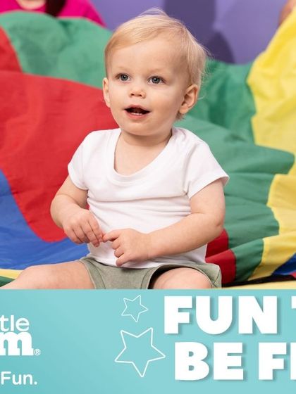 Our 'Fun to be Fit' theme applies to all ages. Here, a toddler enjoys the sensory experience of parachute play, an activity that sparks brain development and builds core strength.