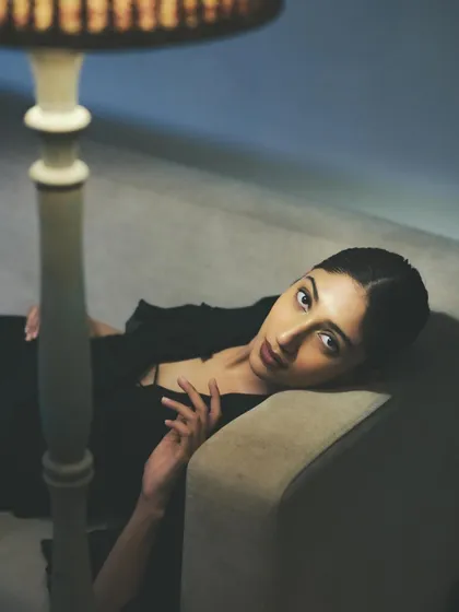 A quiet, cinematic moment. The soft, low light creates a mysterious mood, with the clean makeup and hair ensuring the model's expression is the focus.