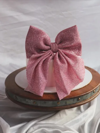 My signature bow cake. This elegant cake is topped with a large, glittering pink bow, making it a gift in itself.