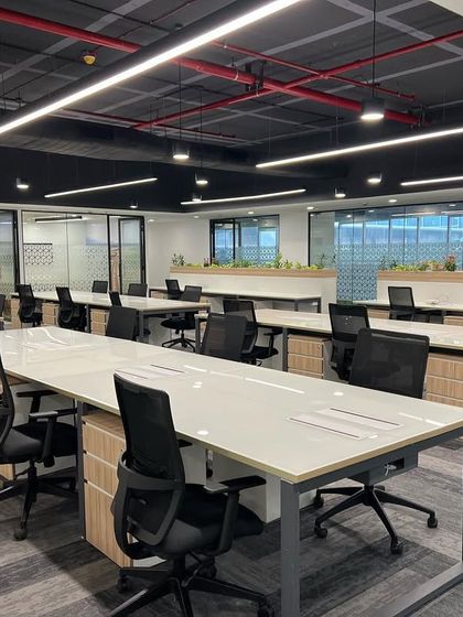The open-plan workstation area for Cube Highways in Hyderabad. The design uses a clean, modern aesthetic with long desks and ergonomic chairs to create an efficient and organized workspace.