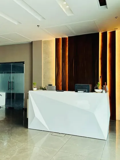The reception area for M/s ALP in Ambala makes a powerful first impression. The design features a striking geometric desk, dramatic back-lighting on a wooden feature wall, and a polished marble floor, creating a modern and professional welcome for all visitors.