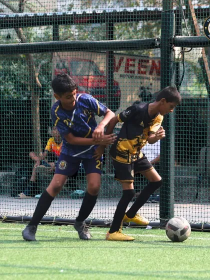 A physical battle for the ball near the sidelines. Our players are trained to be strong and assertive, learning how to shield the ball and win one-on-one duels.