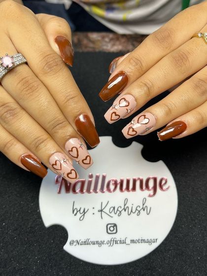 A sweet and earthy design combining solid brown nails with accent nails featuring hand-painted hearts on a nude base.