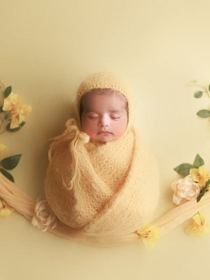 A floral lullaby in soft yellow. This creative setup with the baby suspended on a fabric swing adorned with flowers is so dreamy and unique.