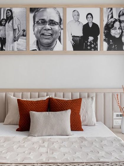 We love making a space feel personal. In this bedroom, we created a custom photo collage of family pictures above a neutral padded headboard, turning a simple wall into a meaningful display of memories.